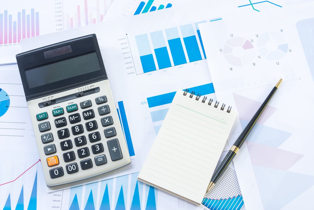 Calculator and Pen with Business Graphs finance document.